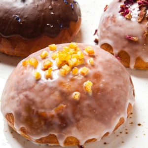 Pączek smażony z konfiturą z płatków róży z lukrem i skórką pomarańczową